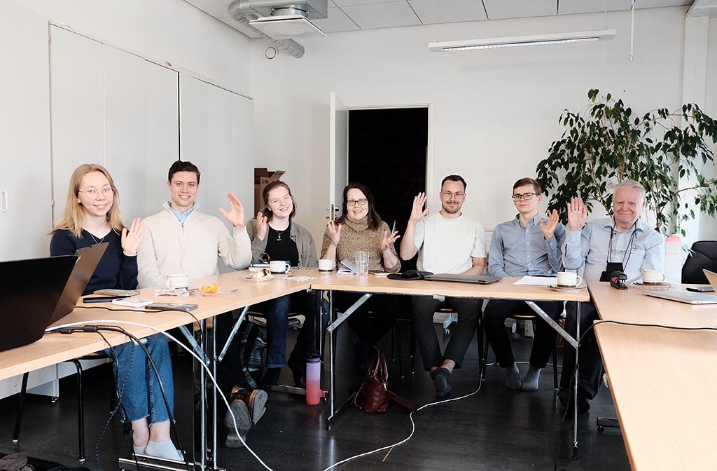 Pöydän ääressä vilkuttaa osa liittokokouksen osallistujista.