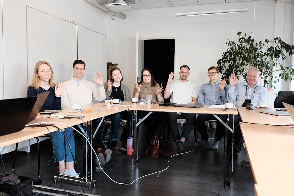 Pöydän ääressä vilkuttaa osa liittokokouksen osallistujista.