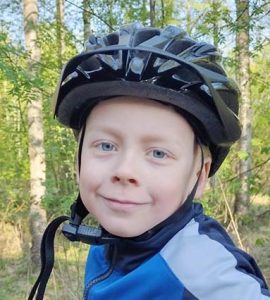 Paulus katsoo kameraan polkupyöräkypärä päässänsä. 